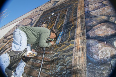 My painting partner, Ted Hanson, adding details to a pick axe on the Gold Mine Mural.